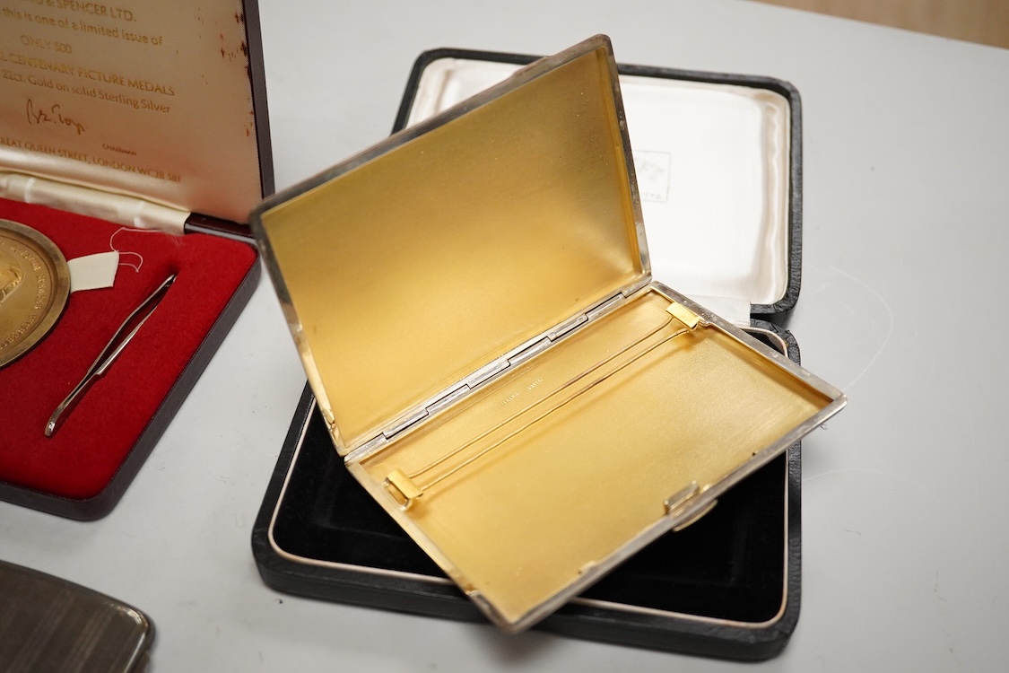 A cased engine turned sterling cigarette case, 11.4cm, a George V silver cigarette case and a cased commemorative limited edition silver gilt Churchill Centenary Picture Medal.